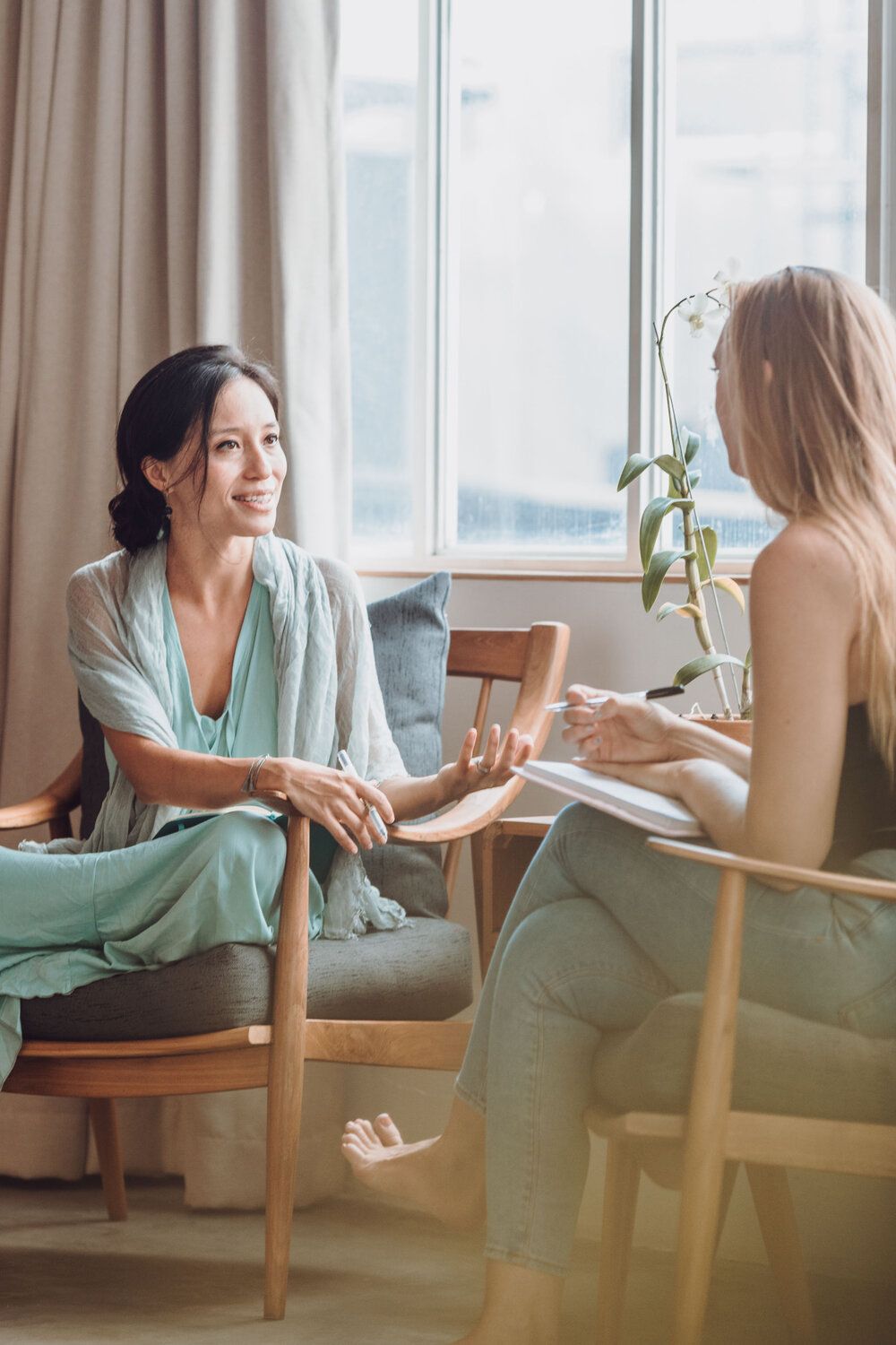 A counsellor and client speaking together in a bright, comfortable room